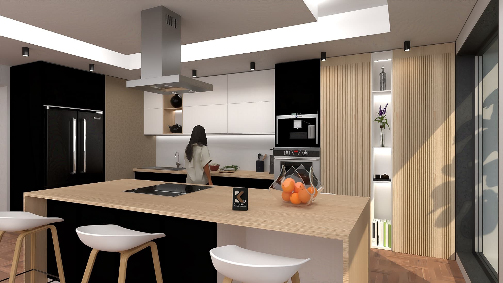 Cocina moderna con isla de madera, taburetes blancos, gabinetes negros y blancos, mujer al fondo.